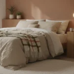 Chambre cocooning avec mur terracotta, linge de lit en lin beige et éclairage doré tamisé